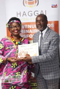 DG de l'entreprise Hope Consulting & Partner qui est entrain de remettre un prix a une lauréates